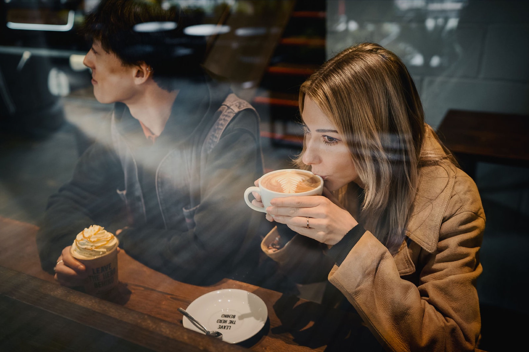 Light falling across a customer drinking coffee by the window.