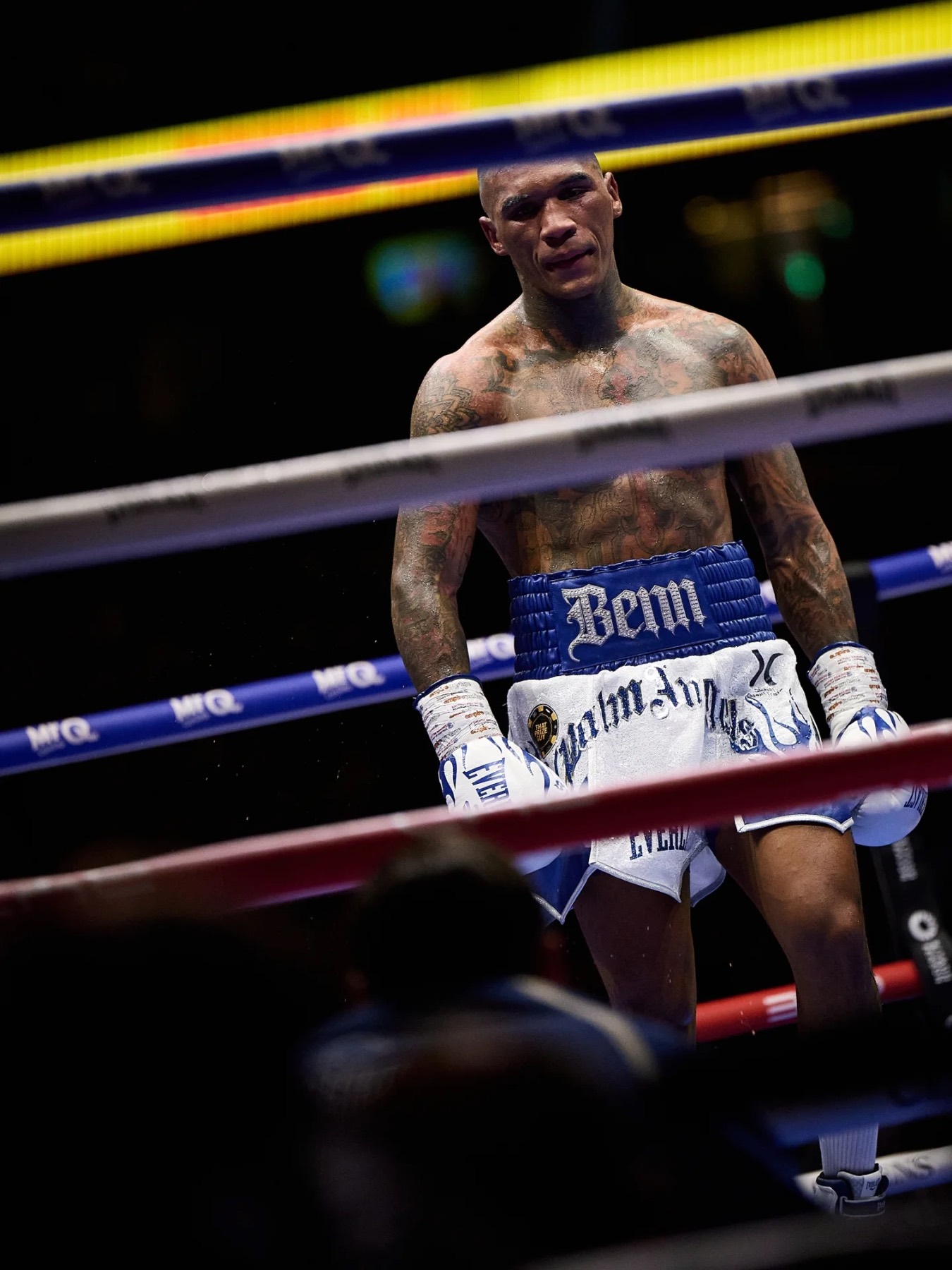 Conor Benn in the ring between rounds, seen through the ropes.