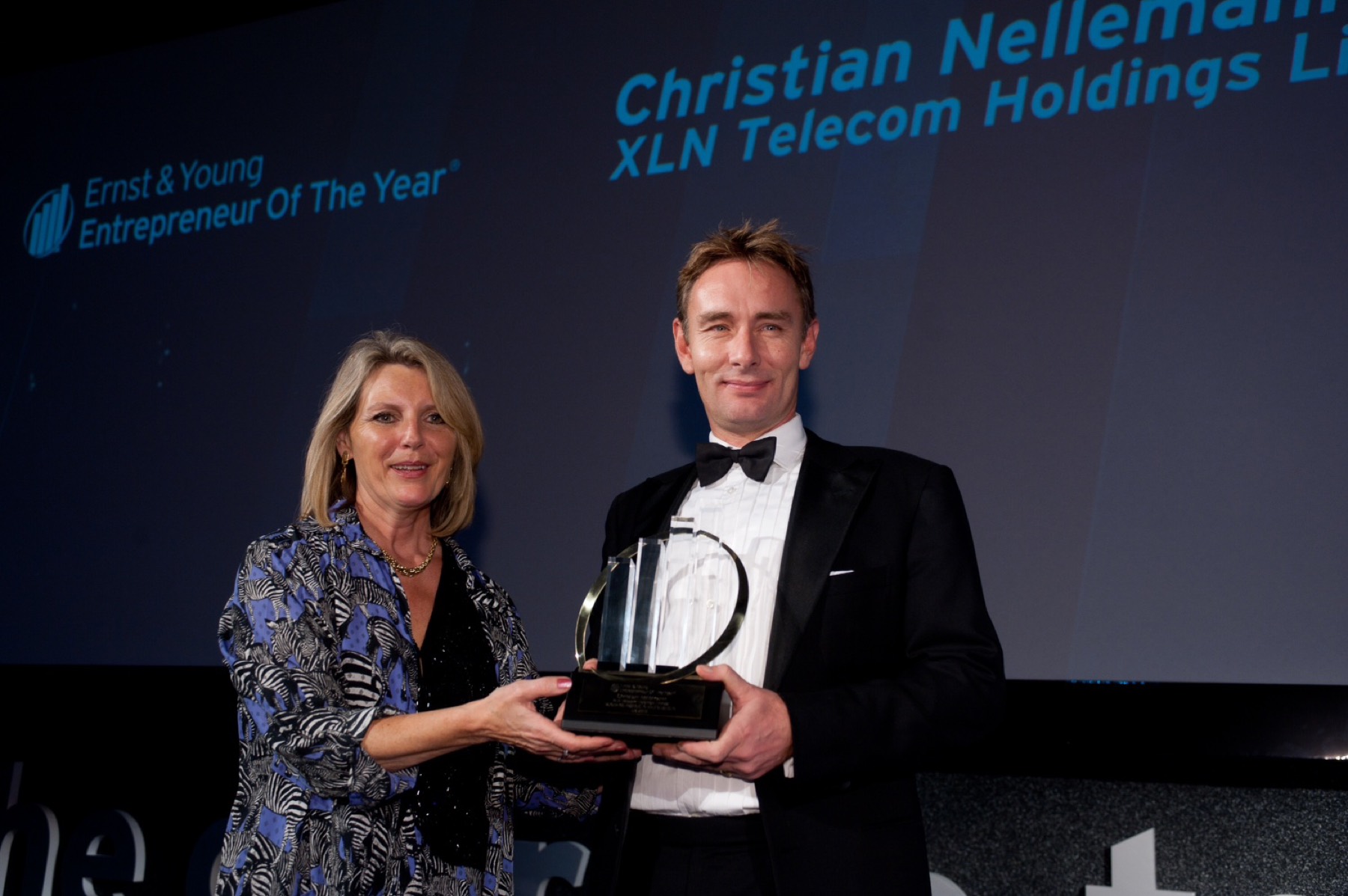 Christian receiving the Entrepreneur Of The Year award on stage.